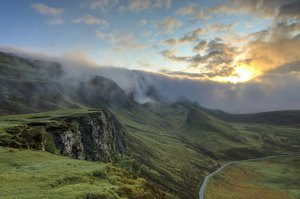 Sunrise lighting up rolling highlands under a golden sky