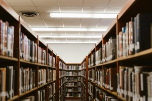 A long aisle of library shelves in Hollis Library
