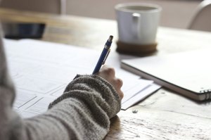 A student writing notes in a planner